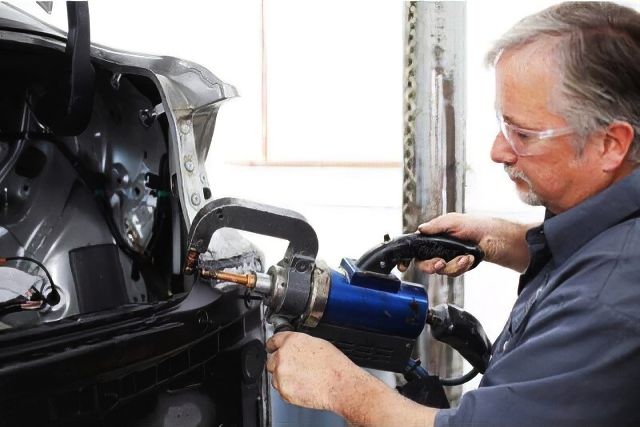 Auto body repair technician working back of car Heritage Collision MI Auto-body-repair-technician-working-back-of-car-Heritage-Collision-MI