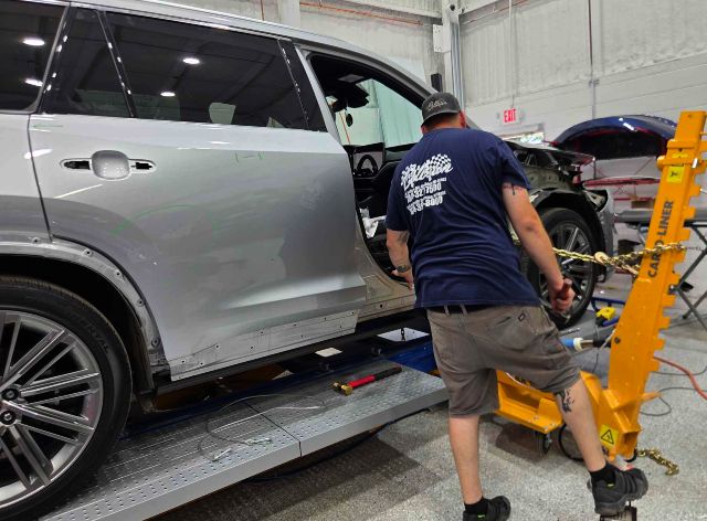 Lexus on Frame Machine with auto body technician adjusting the frame at Heritage Collision Ann Arbor Lexus-on-Frame-Machine-with-auto-body-technician-adjusting-the-frame-at-Heritage-Collision-Ann-Arbor.
