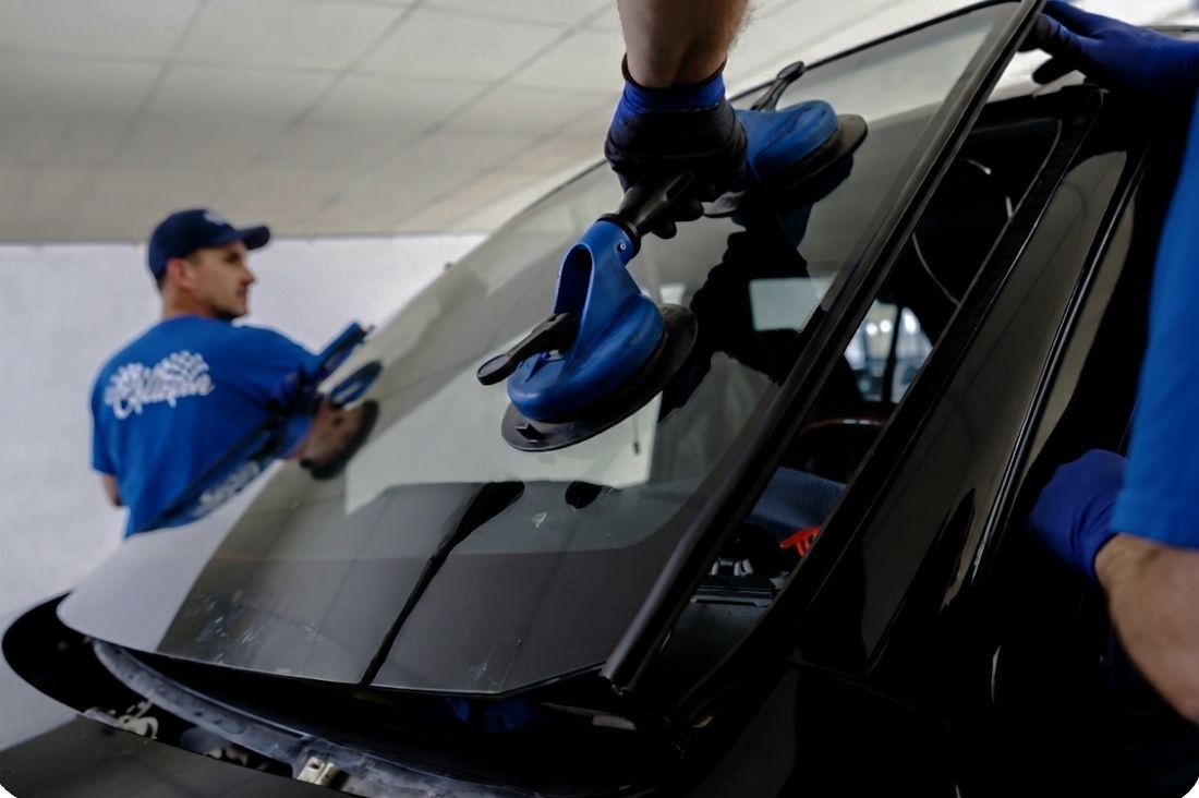 auto body techs lifting out a windshield replacement at Heritage Collision Ann Arbor and Canton (1) auto-body-techs-lifting-out-a-windshield-replacement-at-Heritage-Collision-Ann-Arbor-and-Canton